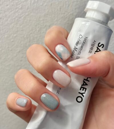 Маникюр на короткие ногти в пастельно-молочной гамме с клетчатым принтом на одном пальце